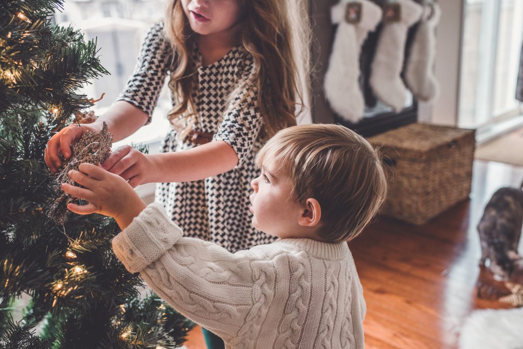 two children decorating a christmas tree 