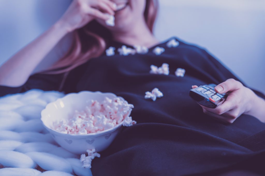 woman watching  movies an learnign english whilst eating popcorn